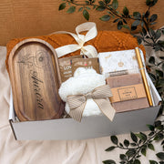 Birth flower gift box with wooden tray with custom name, handmade soap, cozy throw, herbal tea, journal and pen. Customizable text etched into the wooden jewelry tray. the box is wrapped with a ribbon to match the box and be gift ready.