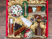 A deluxe gift box with crystals displayed, including a chakra pyramid, chakra tree, tumbled crystals, a bracelet, and a lavender scented candle.